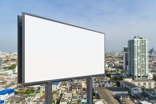 Blank white road billboard with Bangkok cityscape background at day time. Street advertising poster, mock up, 3D rendering. Side view. The concept of marketing communication to promote or sell idea.