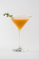 Alcoholic cocktail decorated with thyme in a glass glass on a white background