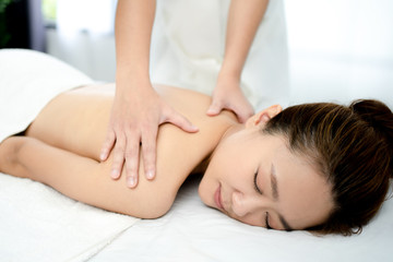 Fototapeta na wymiar Young woman having a relaxing massage in a spa salon