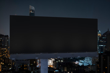 Blank black road billboard with Bangkok cityscape background at night time. Street advertising...
