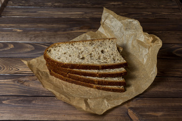 Freshly baked slice of bread sliced ​​on wrapping paper.