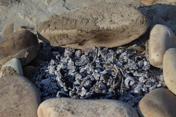 burning charcoal lined with stones by the river