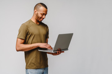 A young african american man working with a laptop pc