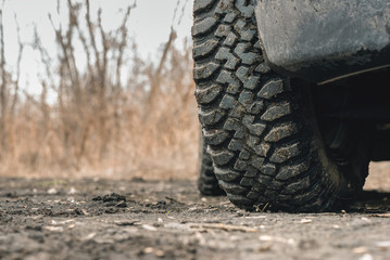 Fototapeta na wymiar Mud terrain wheel of car close up background.