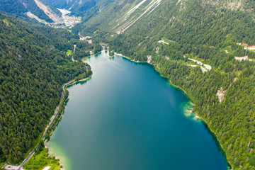 a view from a height of a mountain lake with emerald water and a small island with pine trees