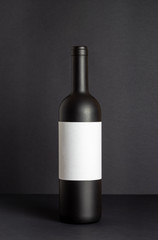 Black wine bottle on a black background. Mock-up. Copy space.