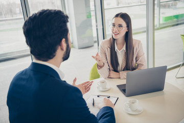 Portrait of his he her she two nice attractive stylish cheerful skilled people sales marketing management meeting gathering sharing experience advice at light white workplace workstation