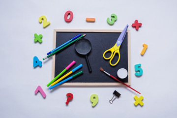 a set of school supplies on a slate