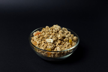 granola in a transparent plate with pieces of tropical fruits