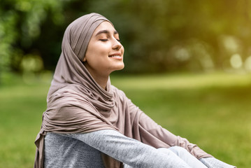 Carefree arab girl taking sunbath at park