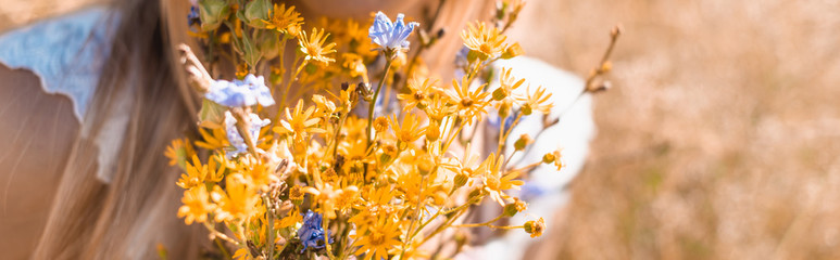 Obraz premium cropped view of woman holding bouquet of wildflowers, website header
