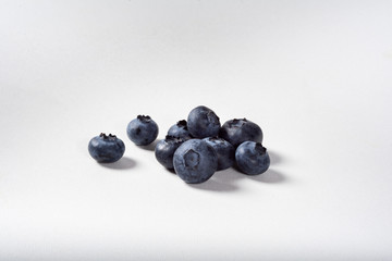 Blueberries on a white background for insulation. A handful of blueberries on the table.