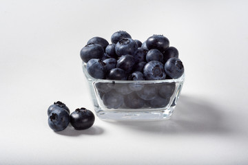 Blueberries on a white background in a glass Cup. Blueberries in a Cup.