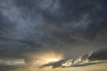 Sunset sky covered with dramatic storm puffy clouds before rain.