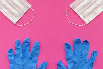 A blue medical mask and glove on a pink background show the middle finger. Space for text. Selective focus.