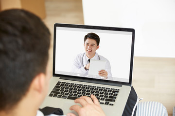 young asian man receiving a diagnosis using tele-medicine network