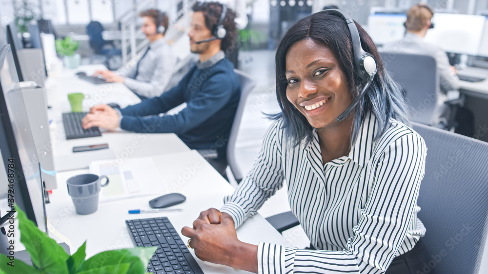 Aufkleber beautiful young female customer service operator smiling for a portrait at a busy modern call center