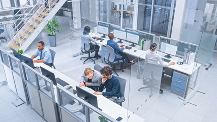 Diverse Multinational Team of Business Managers and Specialists Work on Desktop Computers, Have Discussion with Colleagues. Young and Motivated Business People in Modern Open Office. Shot from Above.