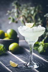 margarita cocktail with lime in a glass on dark background