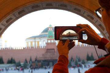 Selective focus of man hand take picture by smart phone at Senate Tower of the Moscow Kremlin on...