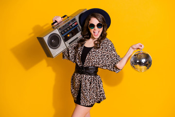 Photo of positive cheerful girl hold glitter ball record boom boos enjoy rejoice retro party wear skirt headwear sunglass isolated over shine bright color background