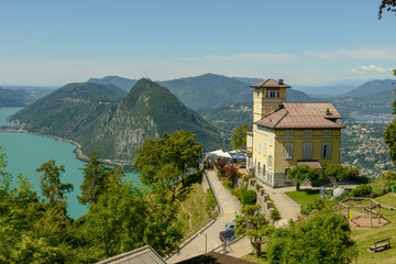 Fototapeta na wymiar Restaurant on Mount Bre and view at the bay of Lugano on Switzerland