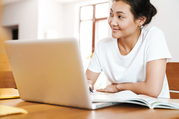 Happy asian female student learning online