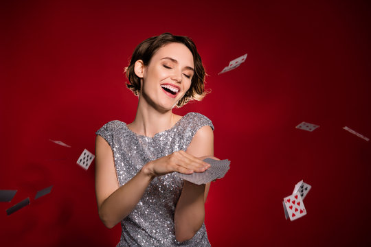 Photo of attractive excited lady las vegas casino club member professional throwing cards air winner laughing wear shine grey dress isolated burgundy gradient dark red color background