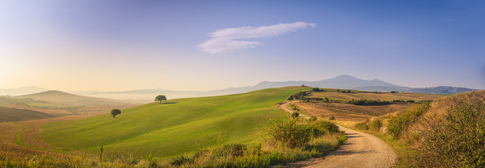 Beautiful morning panorama of the Tuscany mountains, green hills and blue sky.