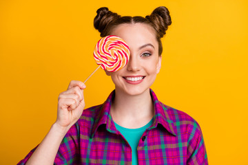 Close-up portrait of her she nice attractive cheerful funky girl wearing checked shirt holding in hand striped lollypop closing eye isolated bright vivid shine vibrant yellow color background