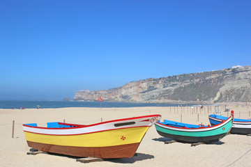 Fototapeta na wymiar Traditional fishing boats on Nazare beach, Portugal 