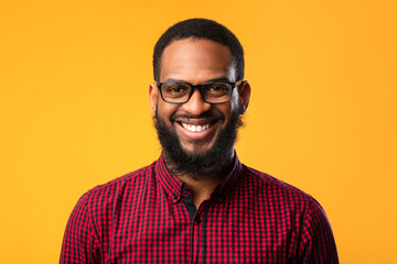 Obraz premium Smiling afro man posing on yellow background
