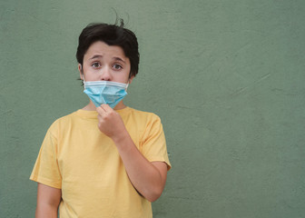 kid who lowers the medical mask over green background