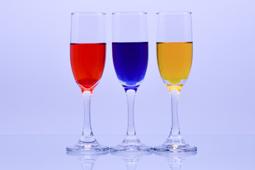 Flute glasses filled with primary colors, red, blue and yellow