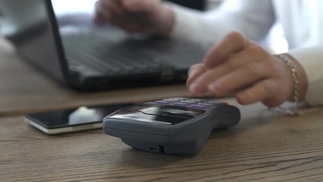 Close-up shot of man applies smartphone to terminal performing successful contactless payment.