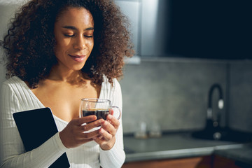 Attractive lady with curly hair enjoying her drink