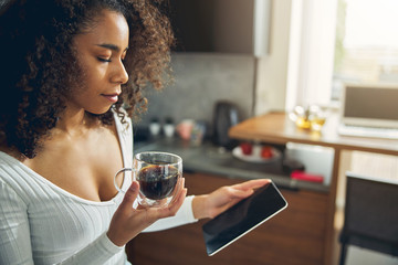 Attractive brunette female looking serious alone in the kitchen