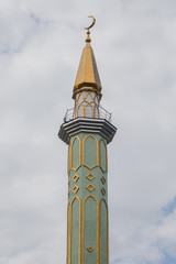 Fototapeta na wymiar View of traditional mosque minaret tower, distinctive architectural feature of mosques. Traditional and typical mosque architectural details.