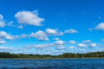 Russia, Lake Ladoga, August 2020. Sky with white clouds over the coastline of a huge lake.