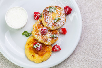 Beautiful morning breakfast: cheesecakes with raspberries