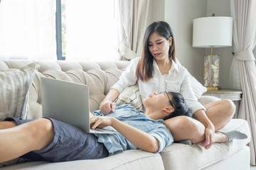 LGBT and bisexual concept.Lesbian couples so happiness with girlfriend Lie on a friend's lap on the sofa, use your laptop, go shopping online together in the living room of the house.