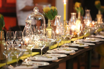 Event table setting with lots of glass and candle lighting.