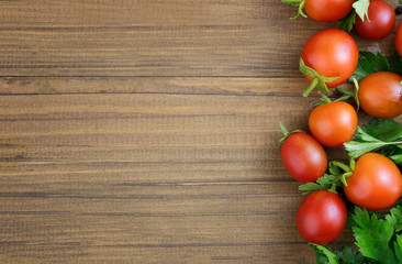Cherry tomatoes on a wooden background. The concept of recipes with tomatoes, canning. Border. Copy space