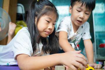 Children boy and girl playing with wooden toy