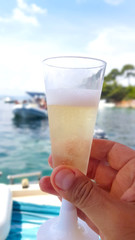 Hand holding a glass of champagne on a boat