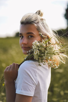 Beautiful Young girl on the field in green grass and flowers. Lifestyle. Enjoy Nature and Summer. Allergy free concept. 