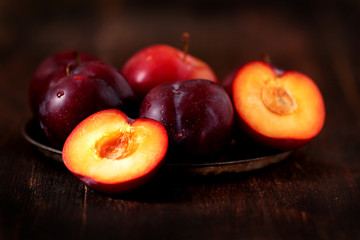 red plum on a wooden table, horizontal