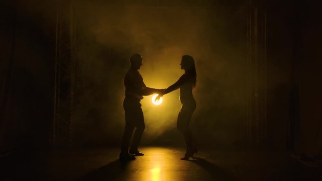 Concept of social dance and relationships. Silhouette of young beautiful couple dancing sensual dance salsa.
