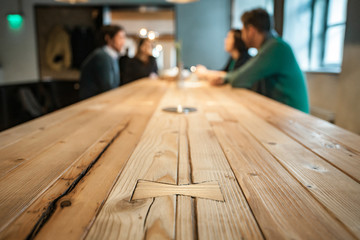 Blurred people sitting at a wooden table
