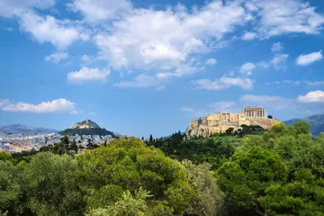 Poster Iconic view of Acropolis hill and Lycabettus hill in background in Athens, Greece from Pnyx hill in summer daylight with great clouds in blue sky. © NPershaj